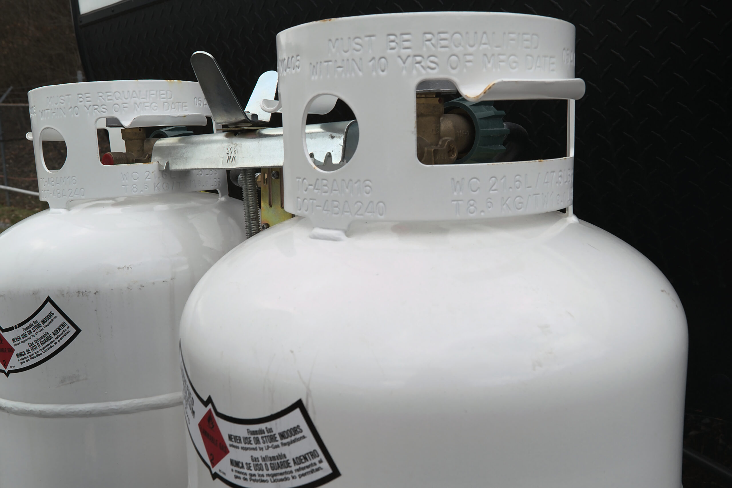 Two 20 pound propane tanks secured to the front of an RV travel Trailer