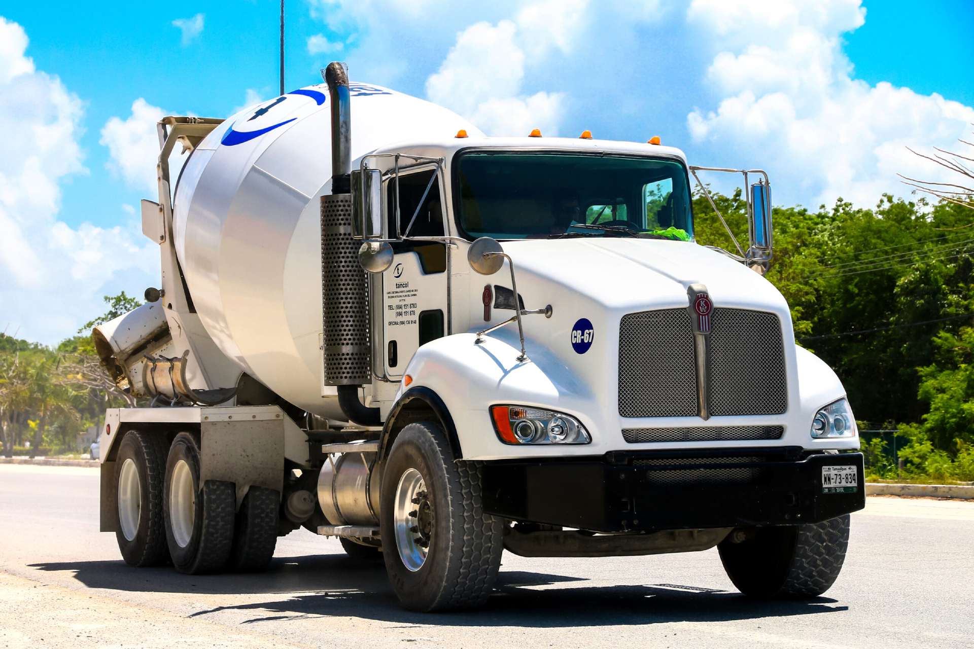 Big white concrete mixer truck on the road front view